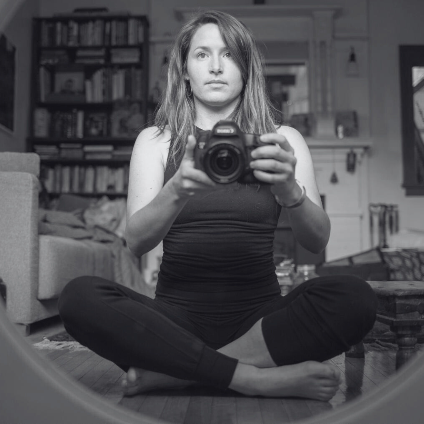 anandi brownstein in black and white holding a camera in front of a mirro