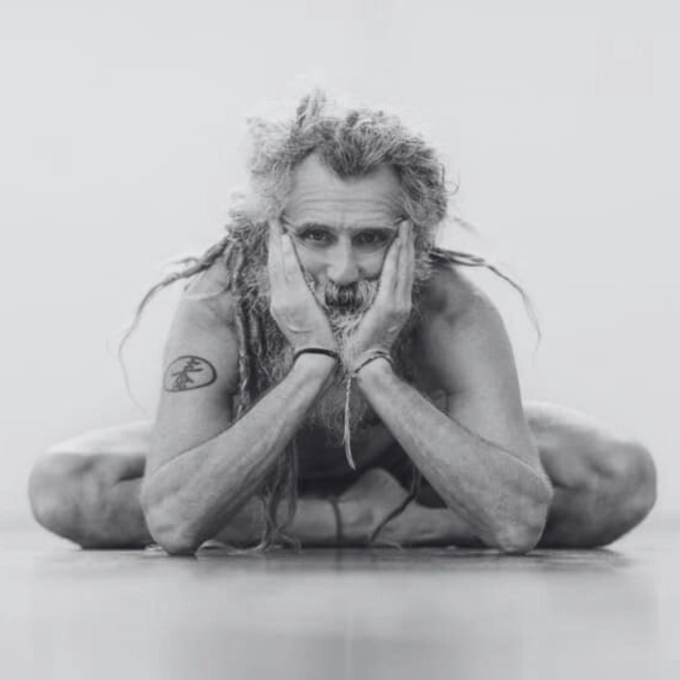 Yoga teacher with dread locks sitting on the floor