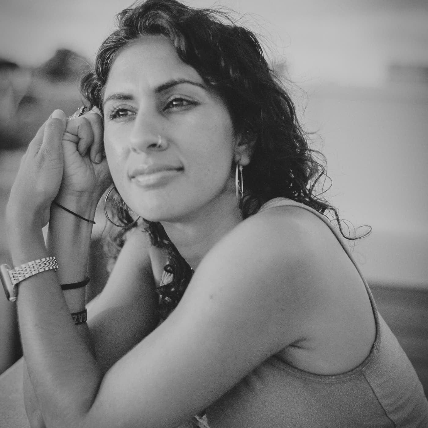 south asian woman smiling to the distance in black and white