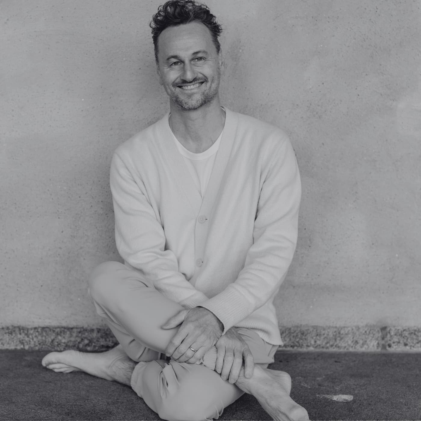 Swedish meditation teacher Magnus Fridh sitting with legs crossed smiling